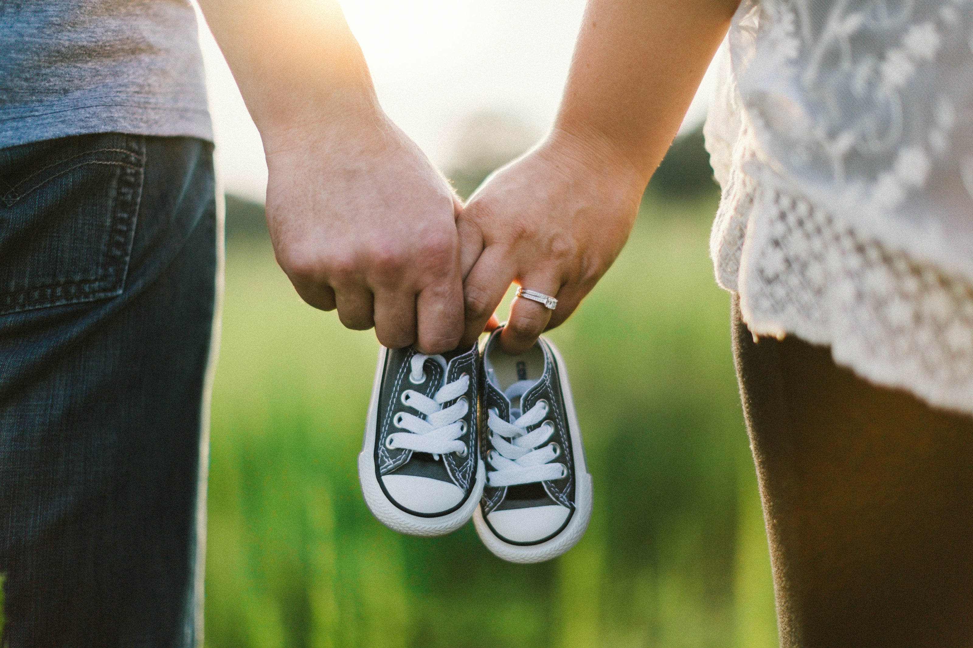 a parent holding a baby's shoes